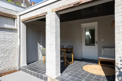a covered patio with a table and a chair at Huys17 in Hasselt