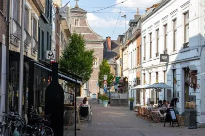 a city street with people sitting at tables on the sidewalk at Huys17 in Hasselt