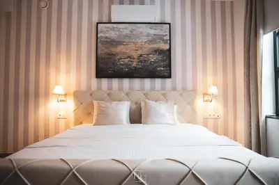 a bedroom with a large white bed with two lamps at La Forteresse in Borgloon