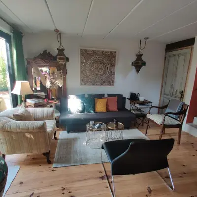 a living room with a blue couch and chairs at De Tuinkamer in Lanaken
