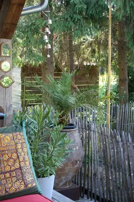 a large vase with plants in it next to a fence at De Tuinkamer in Lanaken
