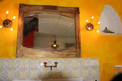 a mirror above a sink in a bathroom at De Tuinkamer in Lanaken