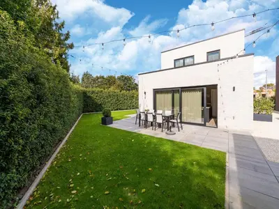 a white house with a patio and green grass at Beaunita Luxe Stay in Hamont in Hamont-Achel