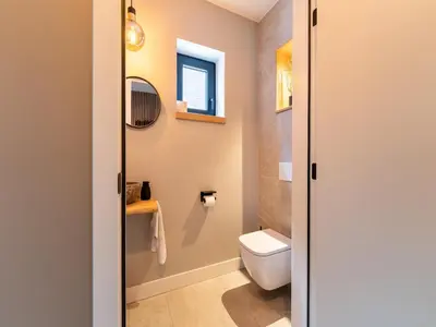 a bathroom with a toilet and a window at Beaunita Luxe Stay in Hamont in Hamont-Achel