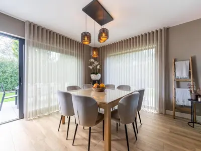 a dining room with a wooden table and chairs at Beaunita Luxe Stay in Hamont in Hamont-Achel