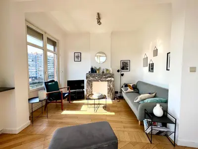 a living room with a couch and a fireplace at Bellevue - Grand appartement pour 5 sur les quais de la Meuse in Liège