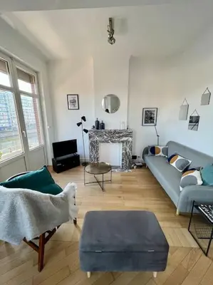 a living room with a blue couch and a fireplace at Bellevue - Grand appartement pour 5 sur les quais de la Meuse in Liège