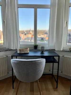 a desk with a chair in front of a window at Bellevue - Grand appartement pour 5 sur les quais de la Meuse in Liège