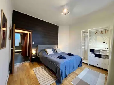 a bedroom with a bed with a blue comforter at Bellevue - Grand appartement pour 5 sur les quais de la Meuse in Liège