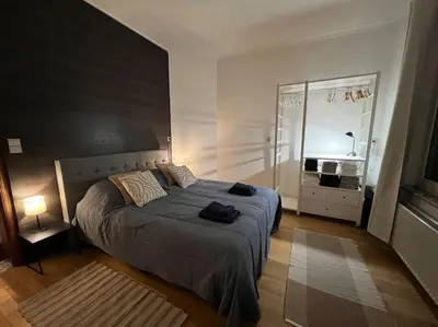 a bedroom with a large bed and a large window at Bellevue - Grand appartement pour 5 sur les quais de la Meuse in Liège