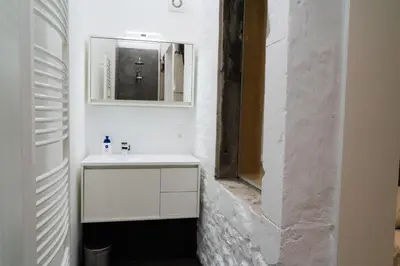 a white bathroom with a sink and a mirror at Cheval Blanc - Holiday Rental in Aubel