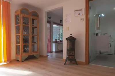a room with a wooden cabinet and a clock in it at Ferienwohnung An den Linden in Kelmis