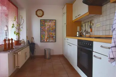 a kitchen with white cabinets and a black dishwasher at Ferienwohnung An den Linden in Kelmis