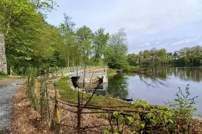 a bridge over a body of water with trees at Ferienwohnung An den Linden in Kelmis