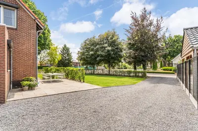 a driveway of a home with a fence at Vakantiewoning 't Hovenshuis in Kinrooi