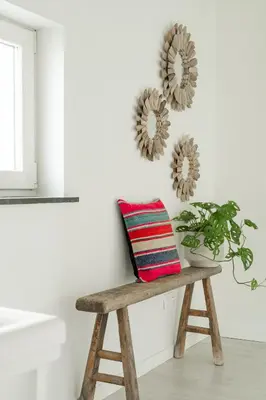 a bench in a room with a pillow and a plant at Vakantiewoning 't Hovenshuis in Kinrooi