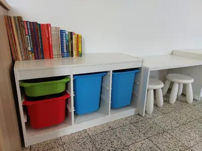 a white table with buckets and a shelf with dvds at Vakantiewoning De Papendaler in Zutendaal