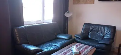 a living room with a leather couch and a table at Cozy studio in Hasselt in Hasselt