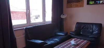 a living room with a leather couch and a chair at Cozy studio in Hasselt in Hasselt