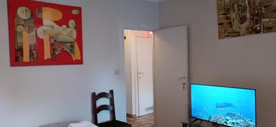 a living room with a television and a painting on the wall at Cozy studio in Hasselt in Hasselt