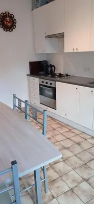a kitchen with a table and a stove and white cabinets at Cozy studio in Hasselt in Hasselt