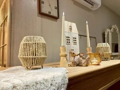 a table with two candles and a toy house on it at Chalet Sint-Hubertus Du Bois in Zutendaal