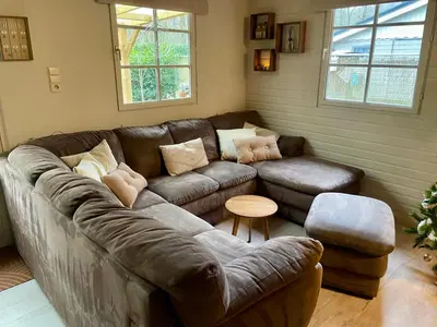 a living room with a leather couch and a table at Chalet Sint-Hubertus Du Bois in Zutendaal