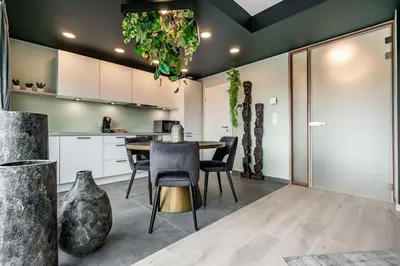 a kitchen and dining room with a table and chairs at La suite Ara, avec sauna in Liège