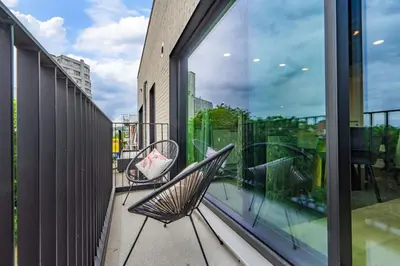 a balcony with a chair and a window at La suite Ara, avec sauna in Liège