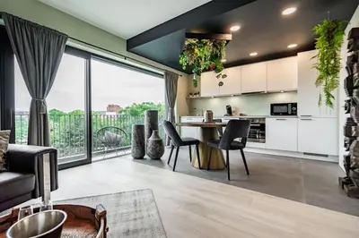 a kitchen and living room with a large window at La suite Ara, avec sauna in Liège