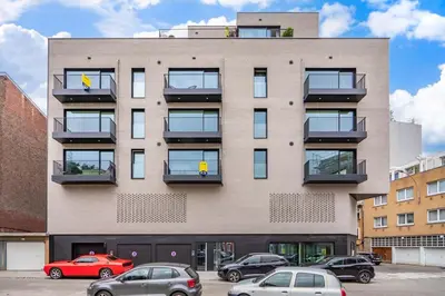 a building with cars parked in front of it at La suite Ara, avec sauna in Liège