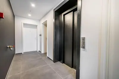 a hallway with black doors and a tile floor at La suite Ara, avec sauna in Liège