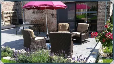 a group of chairs and a table with an umbrella at B&B AntiQua & Qook in Tongeren