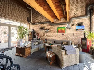 a living room with couches and a brick wall at B&B AntiQua & Qook in Tongeren