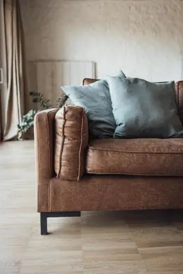 a brown couch sitting in a living room with pillows at Loft 88 in Eupen