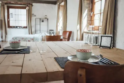 a wooden table with plates and glasses on it at Loft 88 in Eupen