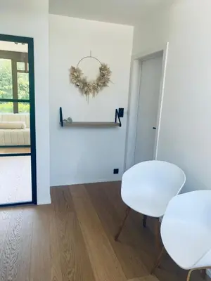 a white room with two white chairs and a mirror at Le Chalet du Pays de Herve in Herve