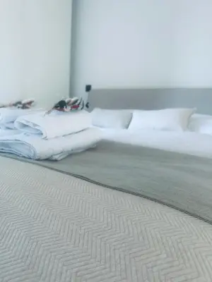 a bed with white sheets and pillows in a room at Le Chalet du Pays de Herve in Herve