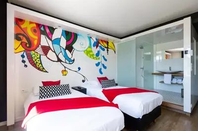 two beds in a bedroom with a mural on the wall at Appart'hotel Urban Lodge in Chaudfontaine