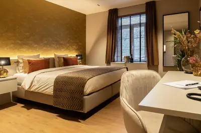 a hotel room with a bed and a table and chairs at Hotel de Boskar Houthalen in Houthalen-Helchteren