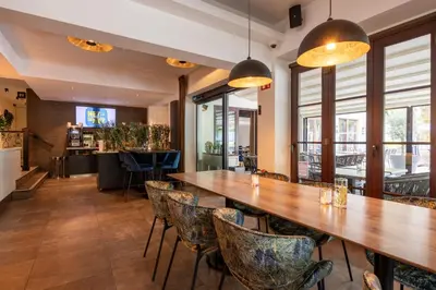 a dining room with a large wooden table and chairs at Hotel de Boskar Houthalen in Houthalen-Helchteren