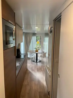 a kitchen with a table and a dining room at Chalet Het Edelhert in Zutendaal