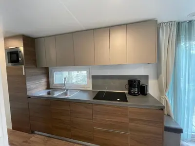 a kitchen with wooden cabinets and a sink at Chalet Het Edelhert in Zutendaal