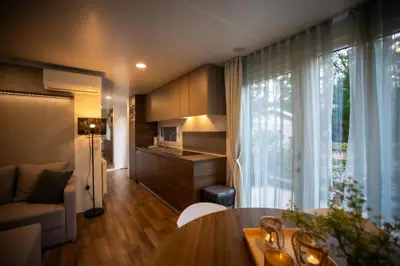 a living room with a table and a kitchen at Chalet Het Edelhert in Zutendaal