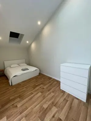 a bedroom with a bed and a dresser in it at Maison 4 chambres avec jardin in Liège
