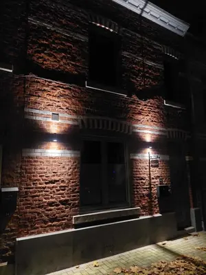 a brick building with lights on it at night at Viator Holidayhome in Tongeren
