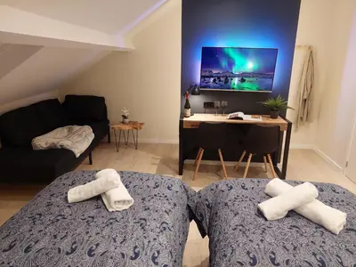 two white towels on two beds in a room at Viator Holidayhome in Tongeren