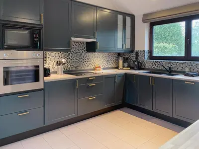 a kitchen with gray cabinets and a window at 8P 4B Beautiful Villa with swimming pool in Zonhoven in Genk