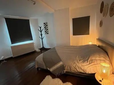 a bedroom with a bed and two large windows at Charmante petite maison à Olne in Olne