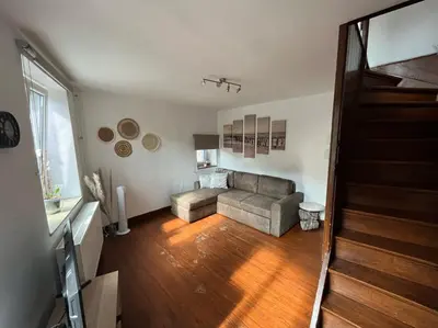 a living room with a couch and wooden floors at Charmante petite maison à Olne in Olne